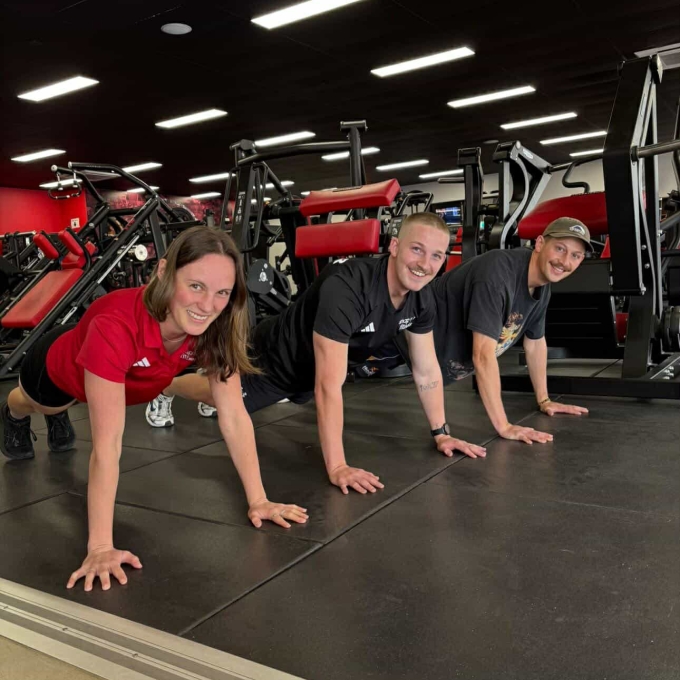 Group doing push ups in a gym